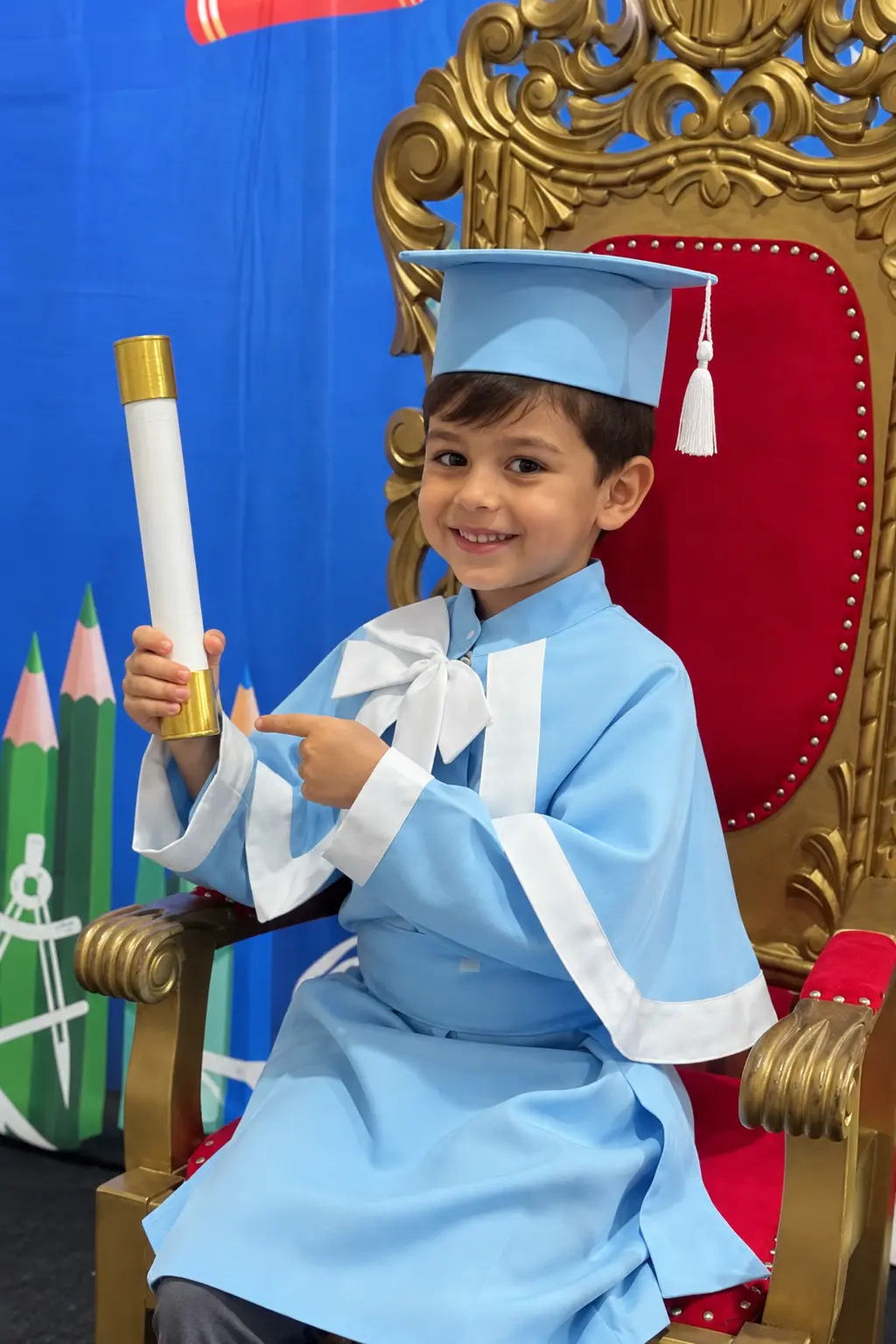 Aluno do Sagres de beca azul na formatura da Educação Infantil